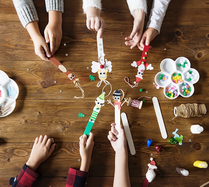 A boy smiling during an ABA therapy session, engaging in a hands-on activity with colorful materials, alongside another child and a therapist in a structured learning environment